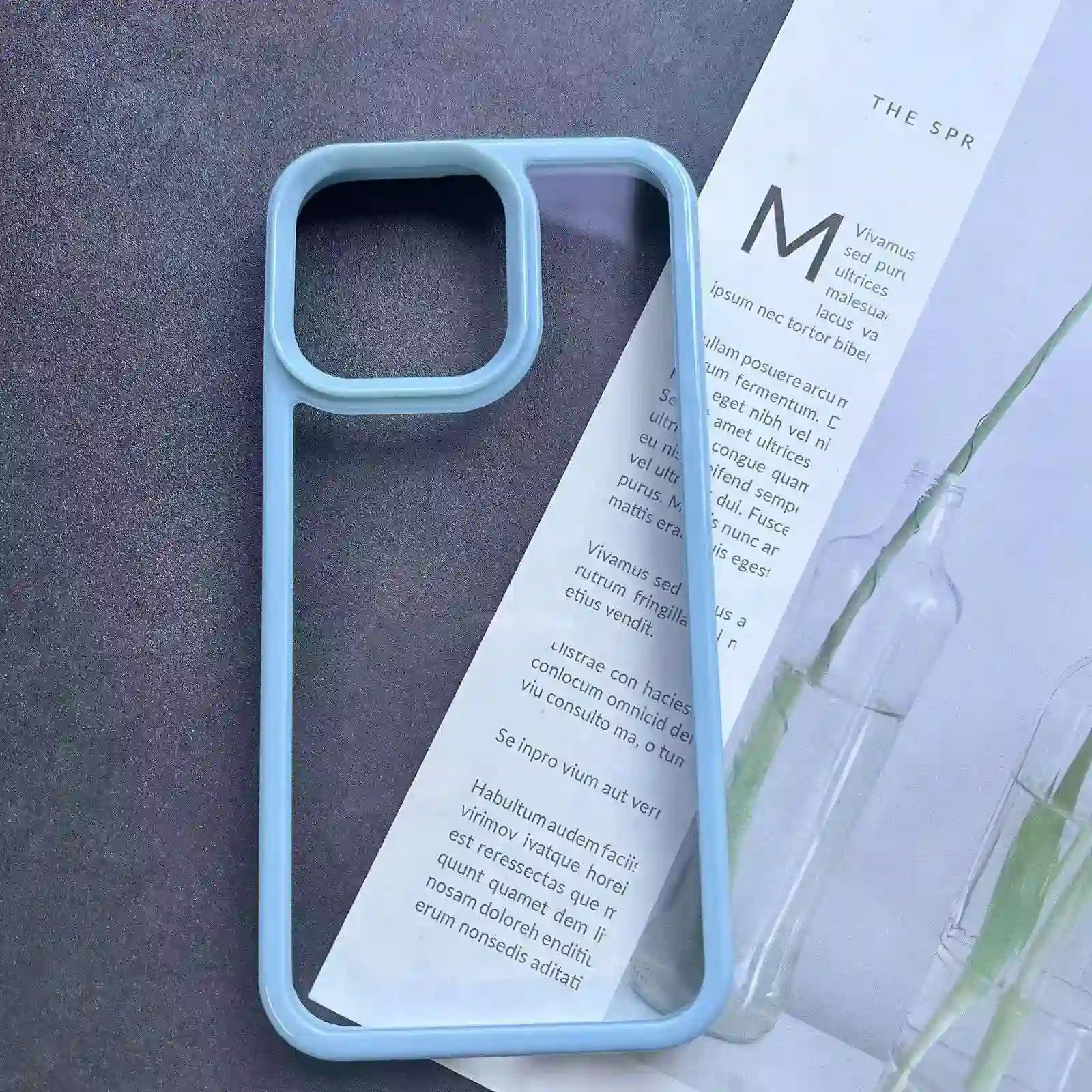 Clear DIY phone case for iPhone with light blue protective frame and transparent back panel, featuring raised camera protection, ready for sticker decoration.