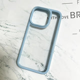 A premium minimalist hybrid phone case featuring a pastel light blue shockproof wide border, a raised camera protection frame, and a crystal clear back panel.