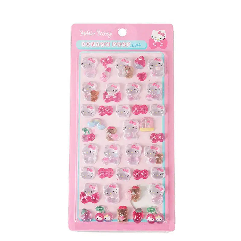 A pink retail pack of Hello Kitty Bonbon Drop Seal 3D glossy stickers with transparent cartoon characters, ribbons, and cherries for DIY crafting.