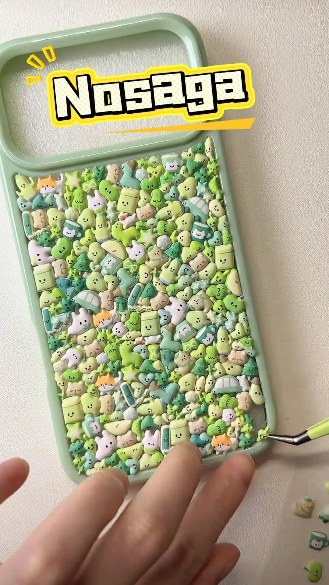 Handcrafted mint green 3D phone case with a dense collage of cute squishy green plants, trees, and small cartoon characters.