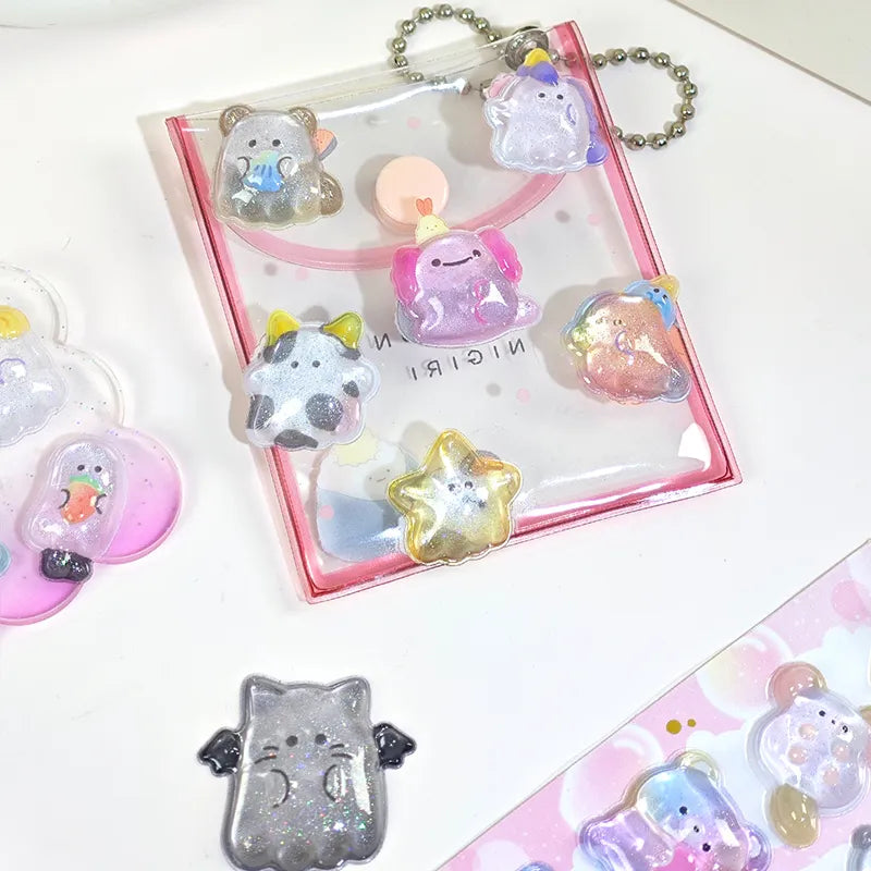 Decorative display of 3D pet crystal stickers used for keychain DIY, featuring cute unicorn and cow designs with holographic effects
