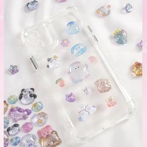 Decorative display of 3D pet crystal stickers used for phone case DIY, featuring adorable ghost, panda, and cat designs with holographic effects
