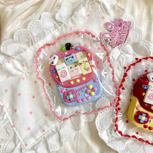 Pink and purple cat-themed game-console squishy in clear packaging.