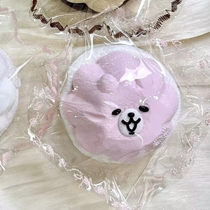 Pink pudding-shaped squishy with a black outlined face in clear packaging.
