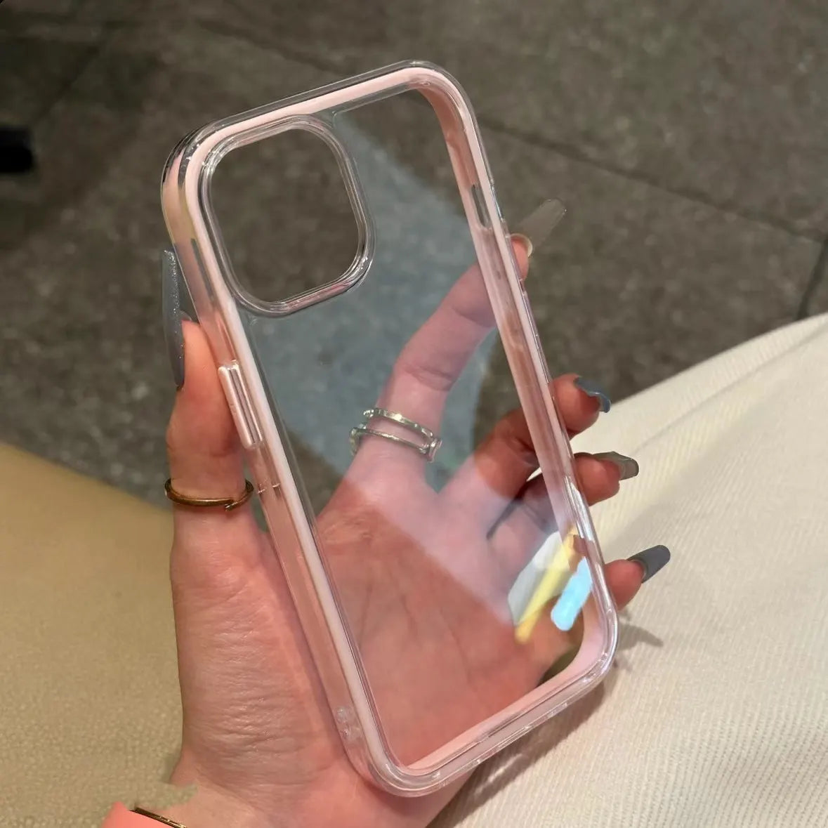 Clear DIY phone case for iPhone with soft pink protective frame and transparent back panel, featuring raised camera protection, ready for sticker decoration.