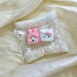 Pink hooded face and white bow cat shapes displayed together in clear packaging.