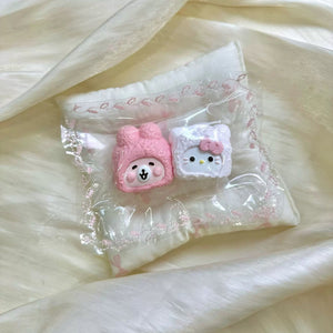 Pink hooded face and white bow cat shapes displayed together in clear packaging.