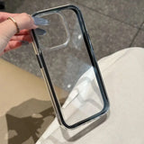 A minimalist hybrid protective phone case with a sleek translucent black border frame and a crystal clear transparent back panel, held in hand.