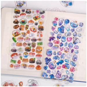Decorative display of 3D crystal stickers with Japanese snack and ocean animal designs, used for journal decoration
