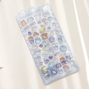 Full display of "BONBON DROP" 3D crystal puffy sticker sheet with starry sky theme, featuring cute bear, cloud, moon, and rainbow designs in pastel blue and purple tones