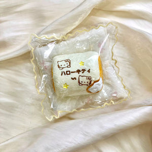Square toasted marshmallow-shaped squishy with cat illustrations in clear packaging.
