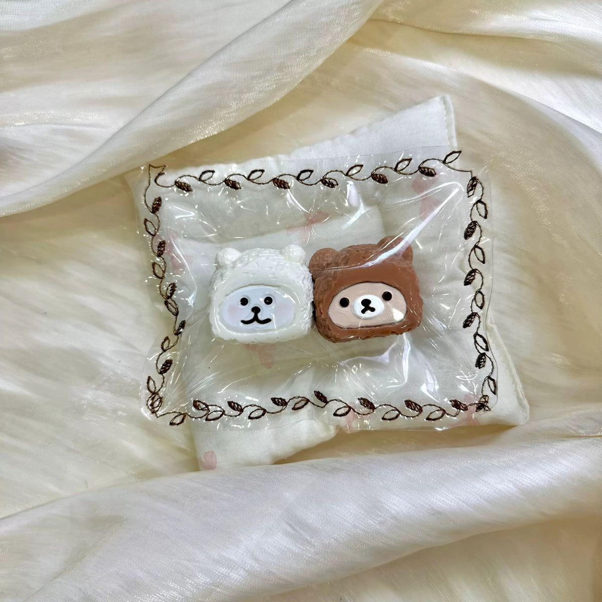 White and brown bear-hood shapes displayed together in clear packaging.