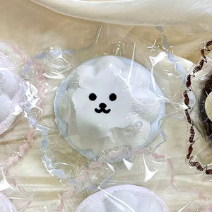 White pudding-shaped squishy with a small black face in clear packaging.